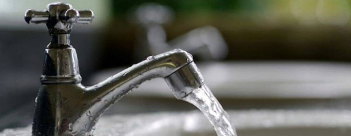 Primo piano di un rubinetto con acqua che scorre