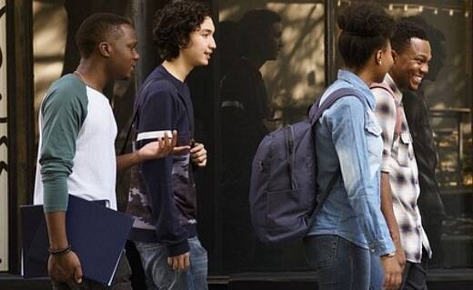 Gruppo multietnico di giovani che cammina per strada sorridendo e parlando tra di loro