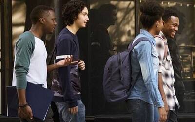 Gruppo multietnico di giovani che cammina per strada sorridendo e parlando tra di loro