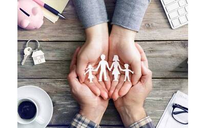 Una famiglia è rappresentata tra le mani di due persone, che la sostengono con cura e protezione