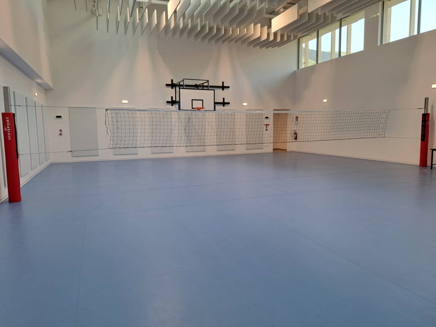 la palestra della scuola media con canestro da basket e rete da pallavolo